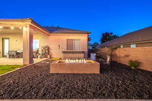 Rear view of property with a patio and an outdoor fire pit