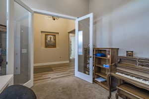 Misc room featuring french doors, light hardwood / wood-style floors, and a notable chandelier