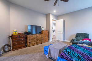 Carpeted bedroom featuring ceiling fan