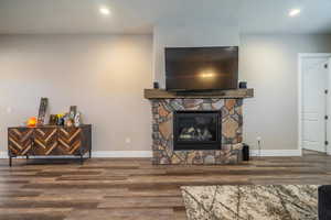 Living room featuring a stone fireplace and hardwood / wood-style floors