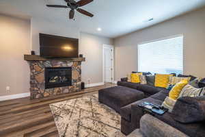 Living room with a fireplace, hardwood / wood-style flooring, and ceiling fan