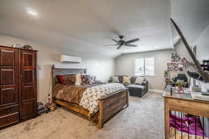 Bedroom featuring light carpet, a textured ceiling, vaulted ceiling, a wall mounted AC, and ceiling fan