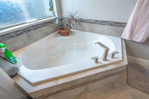 Bathroom featuring tile patterned floors and a relaxing tiled tub