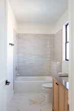 Full bathroom featuring vanity, toilet, and tiled shower / bath