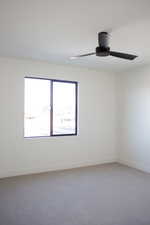 Empty room with ceiling fan and carpet