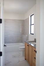 Full bathroom with vanity, toilet, and tiled shower / bath