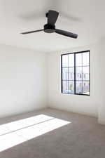 Carpeted empty room with ceiling fan