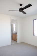 Carpeted spare room featuring ceiling fan