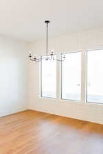 Unfurnished dining area featuring a wealth of natural light and wood-type flooring