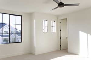 Carpeted empty room featuring ceiling fan