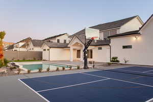 View of basketball court with a fenced in pool