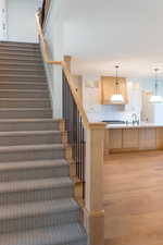 Stairway with hardwood / wood-style floors and sink