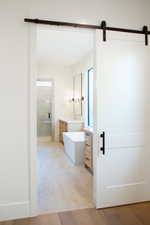 Bathroom featuring plus walk in shower, hardwood / wood-style floors, and vanity