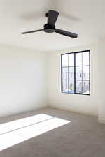 Unfurnished room featuring carpet floors and ceiling fan