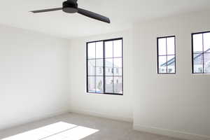 Carpeted empty room featuring ceiling fan