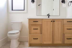 Bathroom featuring tile patterned floors, vanity, and toilet