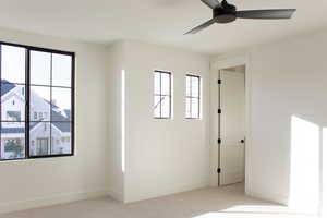 Empty room featuring ceiling fan and light carpet