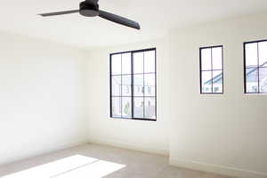 Carpeted empty room with ceiling fan