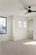 Carpeted spare room featuring ceiling fan