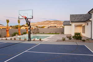 View of sport court featuring a fenced in pool and a mountain view