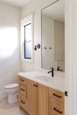 Bathroom with tile patterned flooring, vanity, and toilet