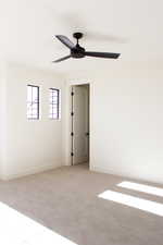 Empty room featuring light carpet and ceiling fan