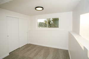 Unfurnished bedroom featuring a closet, carpet floors, and a textured ceiling