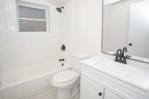 Full bathroom featuring vanity, tiled shower / bath, and toilet