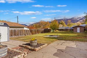 View of yard with a mountain view, a storage unit, and a patio area