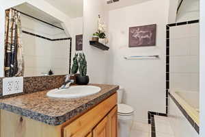 Full bathroom featuring tile patterned flooring, vanity, toilet, and tiled shower / bath