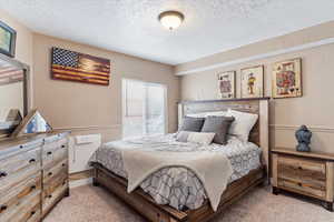 Carpeted bedroom with a textured ceiling