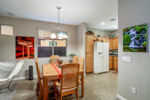 Tiled dining room with a chandelier open to kitchen.