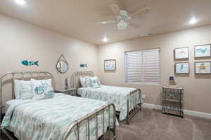 Bedroom with ceiling fan, carpet, and a textured ceiling