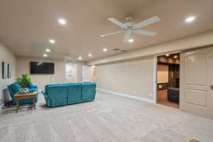 Carpeted living room featuring ceiling fan