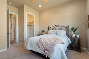 Bedroom with a walk in closet, ceiling fan, a closet, and carpet