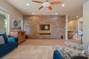 Living room with light wood-type flooring and ceiling fan