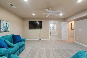 Living area featuring light carpet and ceiling fan