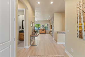 Hall with a textured ceiling and light hardwood / wood-style floors