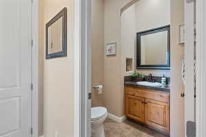 Bathroom featuring tile patterned flooring, vanity, and toilet