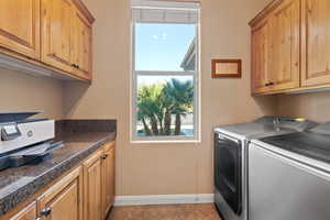 Laundry room featuring washer and clothes dryer, light tile patterned floors, and a healthy amount of sunlight