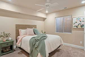 Carpeted bedroom featuring ceiling fan