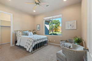 Carpeted bedroom featuring ceiling fan