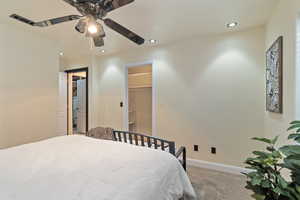 Bedroom with carpet, a walk in closet, a closet, and ceiling fan