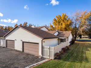 View of side of home featuring a lawn and a garage