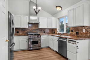 Kitchen featuring white cabinets, appliances with stainless steel finishes, and sink