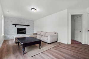 Living room with a fireplace and hardwood / wood-style floors