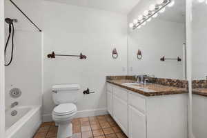 Full bathroom featuring tile patterned flooring, vanity, toilet, and shower / tub combination