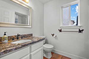 Bathroom featuring tile patterned flooring, vanity, a shower with shower curtain, and toilet