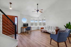 Living room featuring ceiling fan, high vaulted ceiling, and hardwood / wood-style flooring