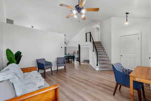 Living room featuring ceiling fan, light hardwood / wood-style floors, and high vaulted ceiling